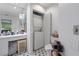 Well-lit bathroom featuring a washer and dryer, toilet, and mirrored vanity with ample storage at 3160 Whispering Pines Ct, Spring Hill, FL 34606
