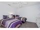 Bright bedroom with ceiling fan and two beds with purple comforters at 3160 Whispering Pines Ct, Spring Hill, FL 34606