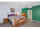 Comfortable bedroom features wood-look flooring, green accent wall, a queen bed and plenty of closet space at 3160 Whispering Pines Ct, Spring Hill, FL 34606