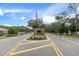 Community entry featuring colorful flowers, an American flag, and a guard house at 3160 Whispering Pines Ct, Spring Hill, FL 34606