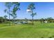 Scenic view of the golf course with lush green fairways, mature trees, and a tranquil lake at 3160 Whispering Pines Ct, Spring Hill, FL 34606