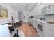 Well-lit eat-in kitchen featuring white cabinets, stainless appliances, terra cotta floors, and adjacent dining area at 3160 Whispering Pines Ct, Spring Hill, FL 34606