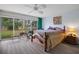 Large bedroom with king-size bed, ceiling fan, and sliding glass doors overlooking wooded area at 3160 Whispering Pines Ct, Spring Hill, FL 34606