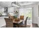Bright dining area featuring modern light fixture, and wicker chairs, adjacent to an open kitchen at 3416 Lema Dr, Spring Hill, FL 34609