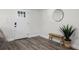 Inviting entryway featuring wood-look floors, a bench, a round mirror, and a bright front door at 3416 Lema Dr, Spring Hill, FL 34609