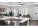Modern kitchen island with stainless steel sink, seating, and view into the open-concept living space at 3416 Lema Dr, Spring Hill, FL 34609