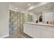 Bathroom featuring a double sink vanity, large mirror and floral shower curtain at 4004 Autumn Amber Dr, Spring Hill, FL 34609