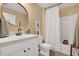 Well lit bathroom features a single sink vanity, round mirror and bathtub with shower at 4004 Autumn Amber Dr, Spring Hill, FL 34609