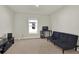 Clean bedroom with a black futon, TV, and large window, with carpet flooring at 4004 Autumn Amber Dr, Spring Hill, FL 34609