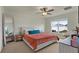 Bright bedroom with a ceiling fan, window, and large full-length mirror at 4004 Autumn Amber Dr, Spring Hill, FL 34609