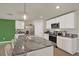 Stylish kitchen island with granite counters, a stainless steel sink, breakfast bar seating, and white cabinets at 4004 Autumn Amber Dr, Spring Hill, FL 34609