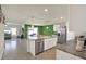Bright kitchen features an island with a sink, granite counters, stainless steel appliances, and an open floor plan at 4004 Autumn Amber Dr, Spring Hill, FL 34609