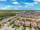 Drone image capturing a neighborhood's layout, showcasing comfortable homes with terracotta roofs and proximity to nature reserves at 4012 Dragonfly Trl, Odessa, FL 33556