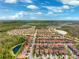 Expansive aerial view of a residential community featuring neatly arranged homes, lakes, and lush green spaces on a sunny day at 4012 Dragonfly Trl, Odessa, FL 33556