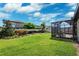 Beautiful backyard with a well-manicured lawn, colorful landscaping, and a cozy screened patio at 4012 Dragonfly Trl, Odessa, FL 33556