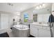 Luxurious bathroom with a large soaking tub, dual vanities, and modern fixtures at 4012 Dragonfly Trl, Odessa, FL 33556