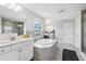 Well-lit bathroom with a soaking tub, dual vanities, and a walk-in shower at 4012 Dragonfly Trl, Odessa, FL 33556