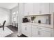 Butler pantry features white cabinetry, white countertops, stainless steel hardware, and herringbone backsplash at 4012 Dragonfly Trl, Odessa, FL 33556