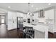 Bright kitchen features white cabinetry, stainless appliances, large island with seating and modern lighting fixtures at 4012 Dragonfly Trl, Odessa, FL 33556
