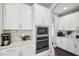 Bright white kitchen features stainless steel appliances, white cabinetry, and herringbone backsplash at 4012 Dragonfly Trl, Odessa, FL 33556
