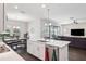 Open kitchen featuring an island with a sink and seating, adjoining dining and living areas for seamless entertaining at 4012 Dragonfly Trl, Odessa, FL 33556