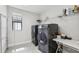 Modern laundry room featuring sleek, dark-colored washer and dryer and ample storage at 4012 Dragonfly Trl, Odessa, FL 33556