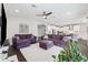 The bright living room has a ceiling fan, dark floors, a decorative rug, and purple couches and loveseat at 4012 Dragonfly Trl, Odessa, FL 33556