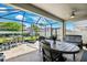 Relaxing screened patio with an outdoor dining set, perfect for enjoying the serene backyard at 4012 Dragonfly Trl, Odessa, FL 33556