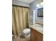 Clean bathroom features a vanity with granite countertop, toilet and a shower with a shower curtain at 4235 Sheldon Pl # 4235, New Port Richey, FL 34652