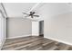Bright bedroom featuring hardwood floors and a ceiling fan, door leads to a bathroom at 4503 Jacona Dr, Hernando Beach, FL 34607