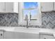 Farmhouse sink and faucet with chevron backsplash and window view at 4503 Jacona Dr, Hernando Beach, FL 34607