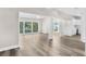 Open-concept living space with hardwood floors and natural light connects seamlessly to a kitchen and outdoor patio at 4503 Jacona Dr, Hernando Beach, FL 34607