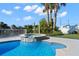 Outdoor pool and jacuzzi surrounded by lush landscaping and blue skies at 4503 Jacona Dr, Hernando Beach, FL 34607