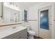 Bathroom with gray vanity, wainscotting, and a window providing natural light at 4559 Crescent Rd, Spring Hill, FL 34606
