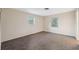 Neutral bedroom featuring two windows, carpet, and light-colored walls at 4559 Crescent Rd, Spring Hill, FL 34606