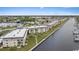 Aerial view of waterfront condos with manicured lawns and boat docks along the canal, showcasing the neighborhood's layout at 4632 Marine Pkwy # 201, New Port Richey, FL 34652