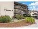 Exterior view of Tower 3 featuring well-maintained landscaping and open-air walkways and covered parking at 4632 Marine Pkwy # 201, New Port Richey, FL 34652