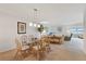 Open-concept living and dining area featuring a glass-topped table with seating for six at 4632 Marine Pkwy # 201, New Port Richey, FL 34652