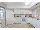 Bright kitchen with white cabinets and appliances and tile flooring at 4632 Marine Pkwy # 201, New Port Richey, FL 34652