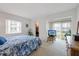 Bright primary bedroom with a floral bedspread, closet, and exterior view at 4632 Marine Pkwy # 201, New Port Richey, FL 34652