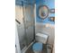 A bathroom featuring a glass-door shower, white tiles, and blue accents at 4653 Cambridge Ave # 4653, New Port Richey, FL 34652