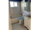 A bathroom featuring white tile, blue trim, and a combined tub and shower at 4653 Cambridge Ave # 4653, New Port Richey, FL 34652