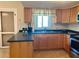 Cozy kitchen features wooden cabinets, stainless steel appliances, and a window with a sink at 4653 Cambridge Ave # 4653, New Port Richey, FL 34652