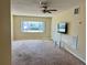 The living room features a bright window and a ceiling fan, with a TV mounted on the wall at 4653 Cambridge Ave # 4653, New Port Richey, FL 34652