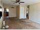 Bright living room featuring neutral walls, ceiling fan, and seamless flow into the kitchen area at 4653 Cambridge Ave # 4653, New Port Richey, FL 34652
