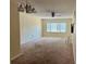 Spacious living room featuring neutral walls, plush carpet, ceiling fan and bright natural light at 4653 Cambridge Ave # 4653, New Port Richey, FL 34652