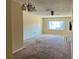 Open living room with a chandelier, a ceiling fan and a bright window offering natural light at 4653 Cambridge Ave # 4653, New Port Richey, FL 34652