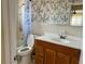 Bathroom with tub and shower, patterned wallpaper, tiled walls, a vanity, and a large mirror at 5335 Embassy Ave # 5335, New Port Richey, FL 34652