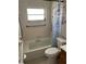 Bathroom with accessibility bars and shower, tiled walls, and a toilet at 5335 Embassy Ave # 5335, New Port Richey, FL 34652