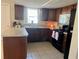 Kitchen area featuring countertops, cabinets, black appliances, tile flooring, and window at 5335 Embassy Ave # 5335, New Port Richey, FL 34652
